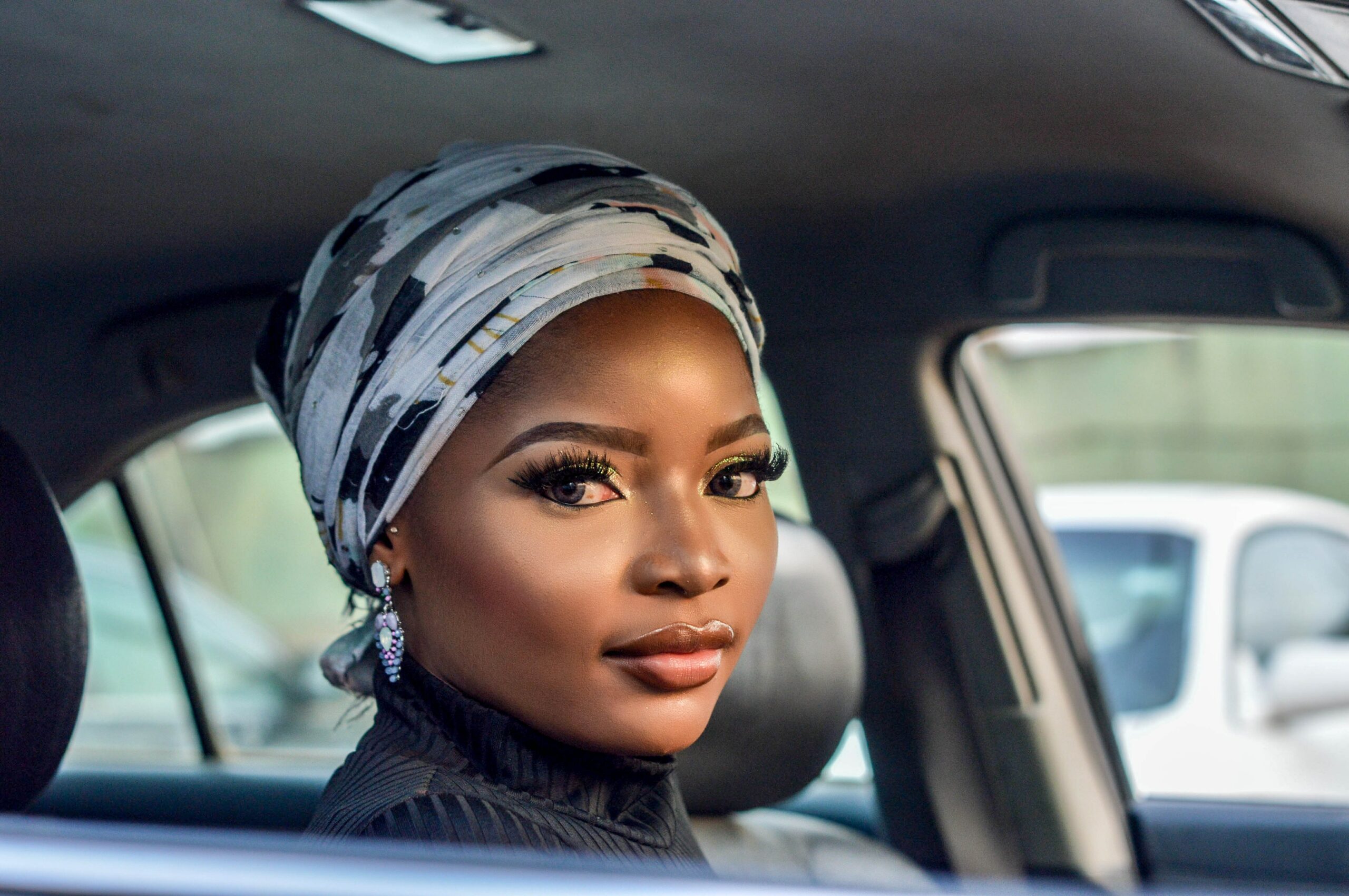 jeune femme afro prise en photo dans sa voiture